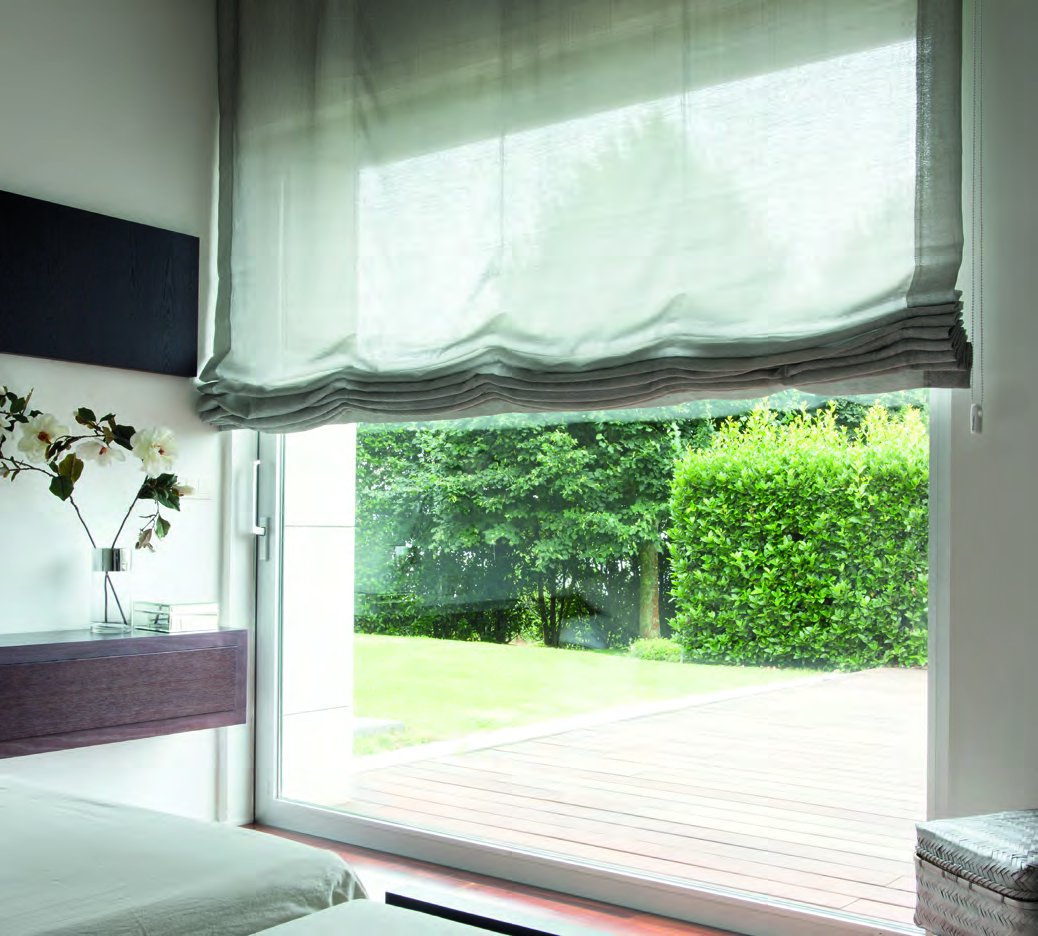 Roman shade in linen fabric facing a garden